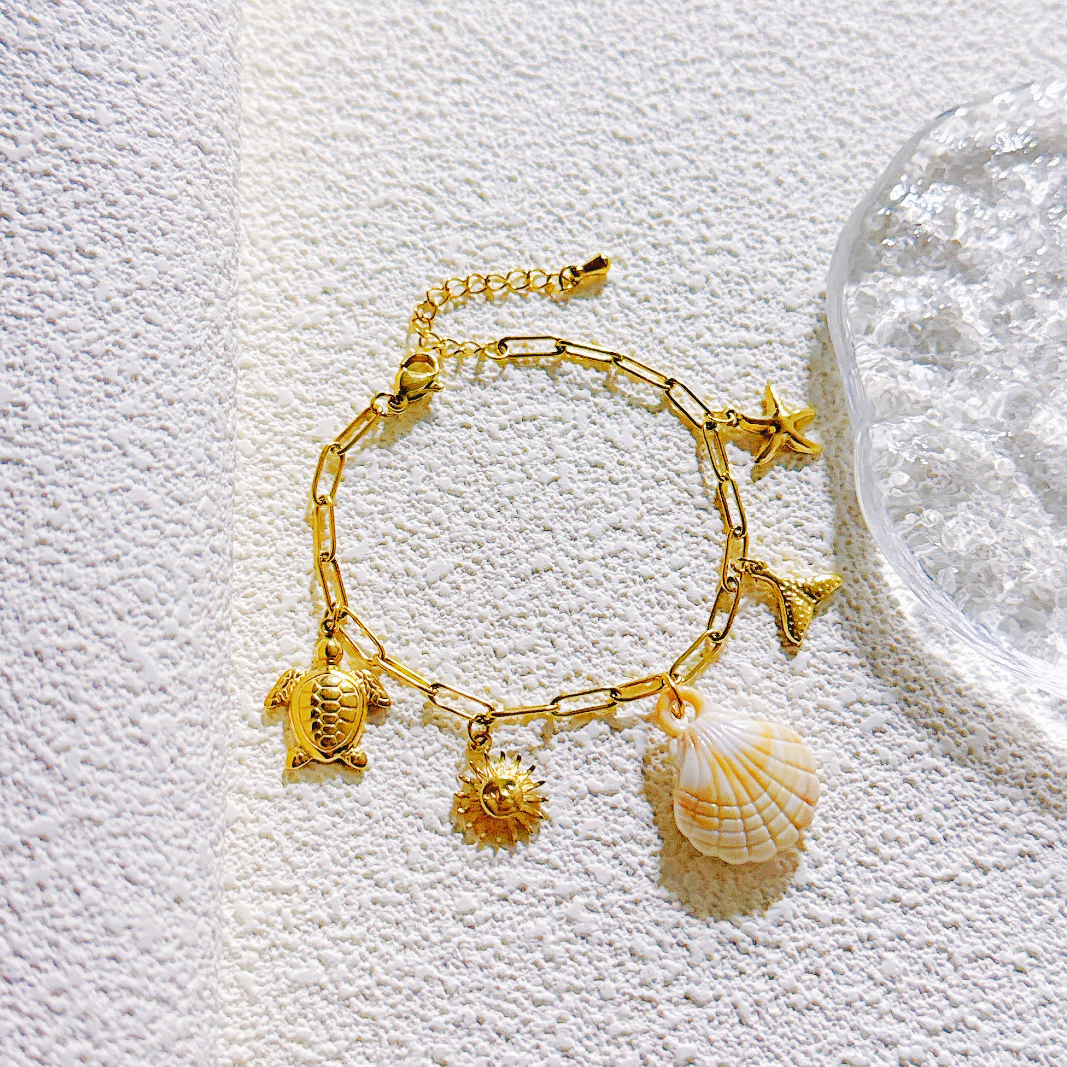 Vergoldetes Armband mit maritimen Anhängern aus Edelstahl, darunter Schildkröte, Sonne, Seestern & Muschel